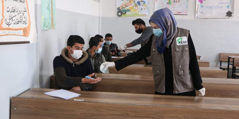 In cooperation with the Free University of Aleppo, student volunteers distribute medical masks and hand sanitizer to students sitting for exams. March 2021. Credits: Free University of Aleppo